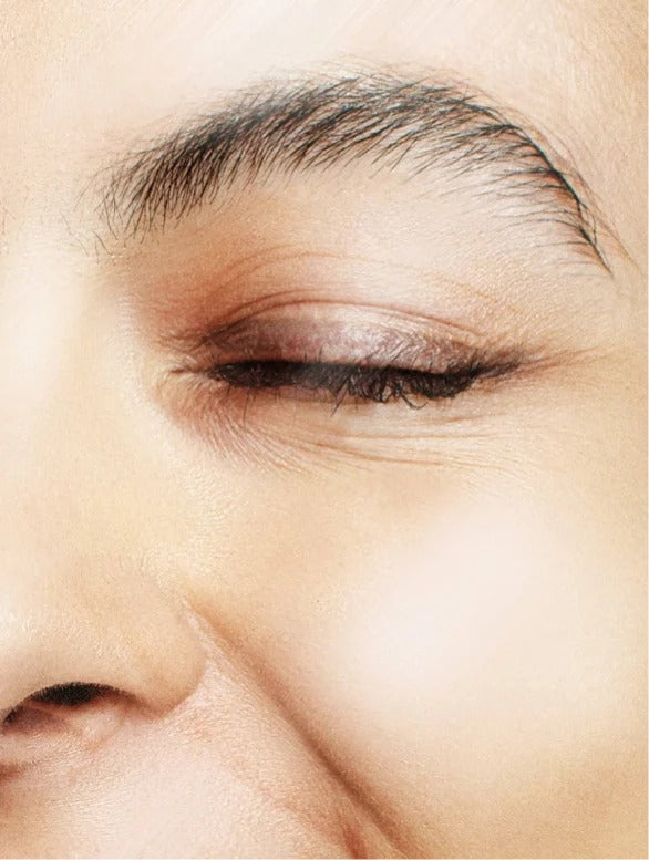 Close-up of an eye with makeup, focusing on the eyelid and eyebrow area.