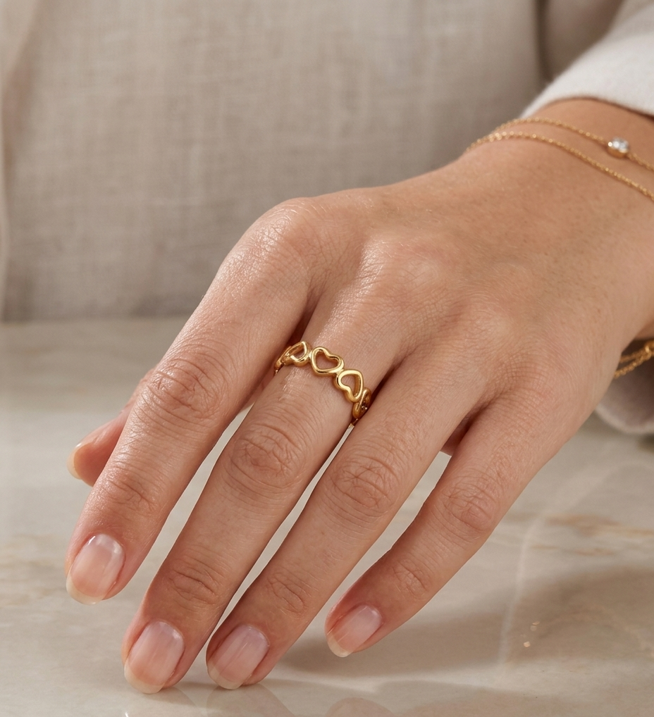 Gold ring on a hand with a neutral background
