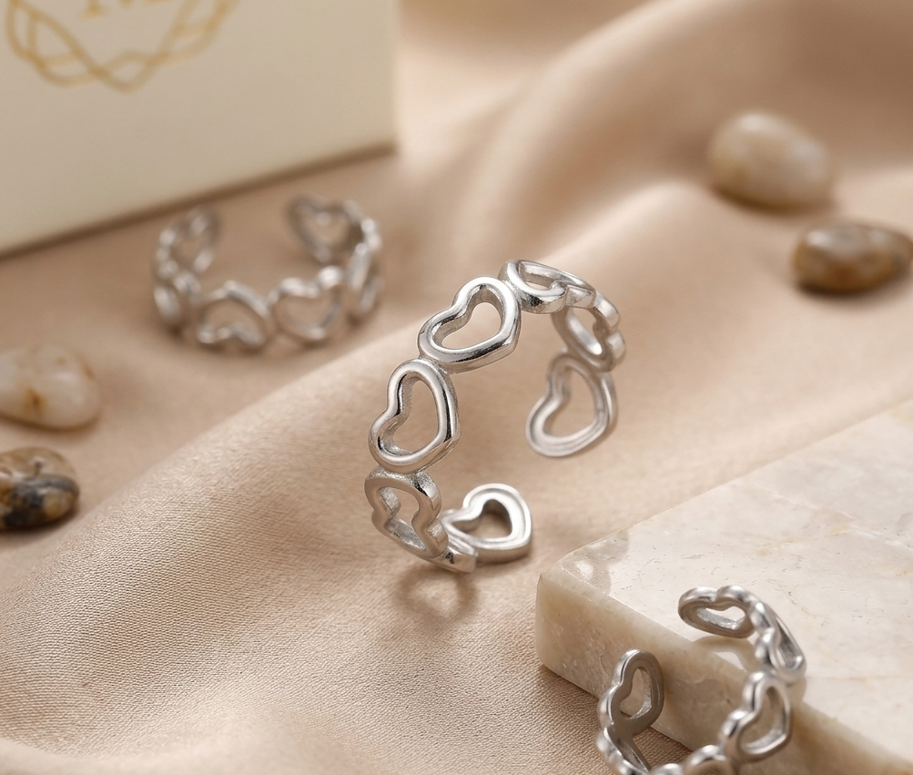 Silver heart-shaped ring on a beige fabric background