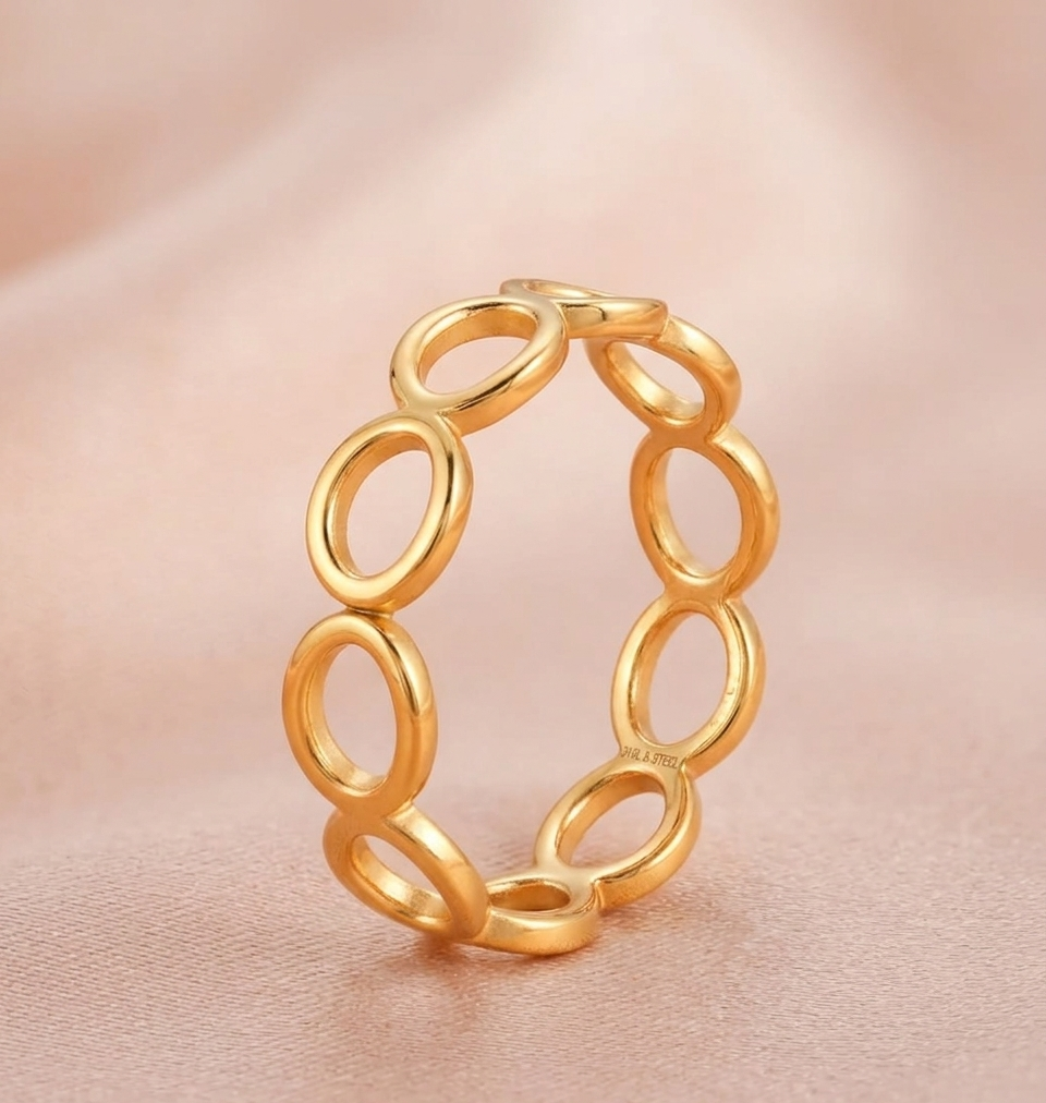 Gold chain-style bracelet on a soft pink background