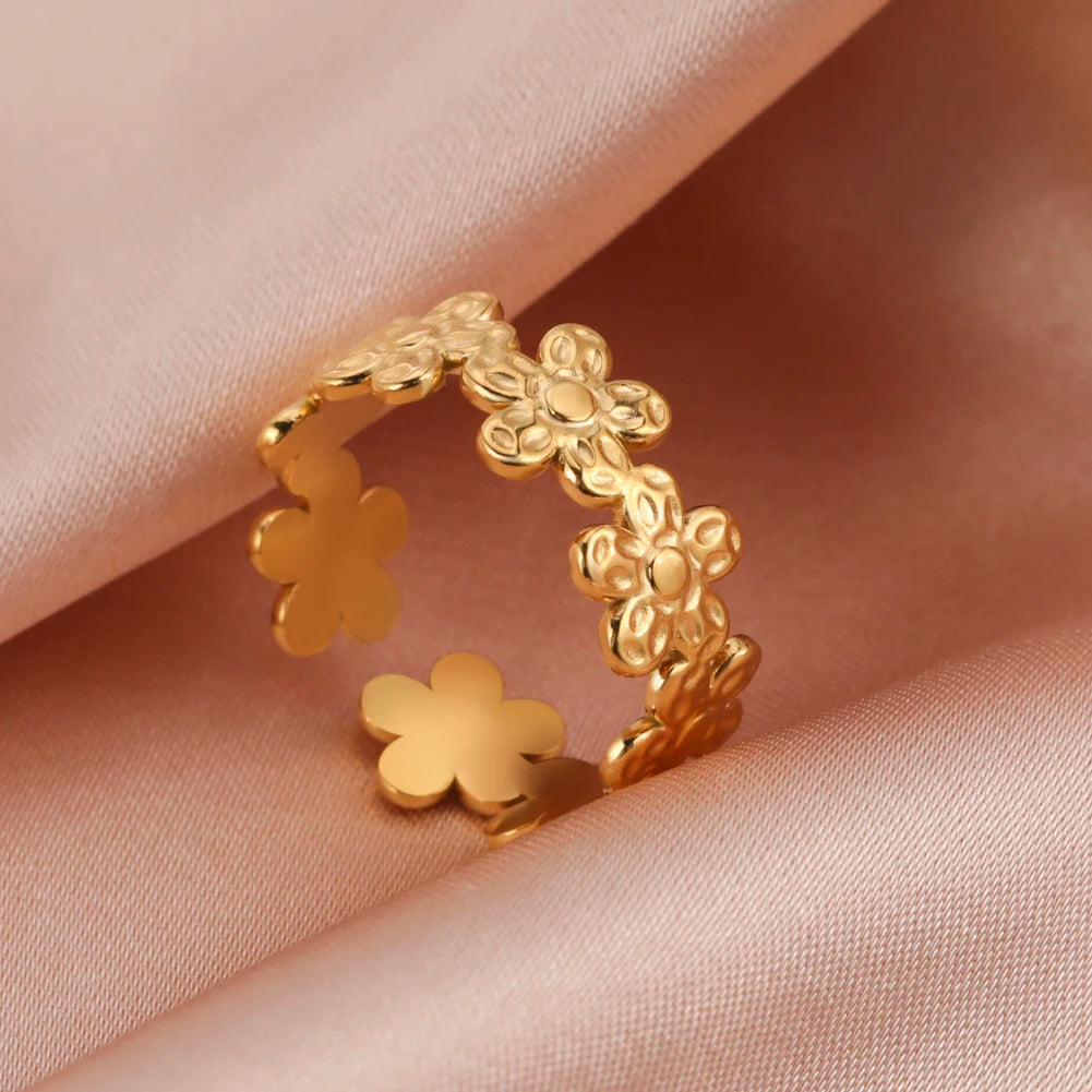Gold floral ring on a soft pink fabric background
