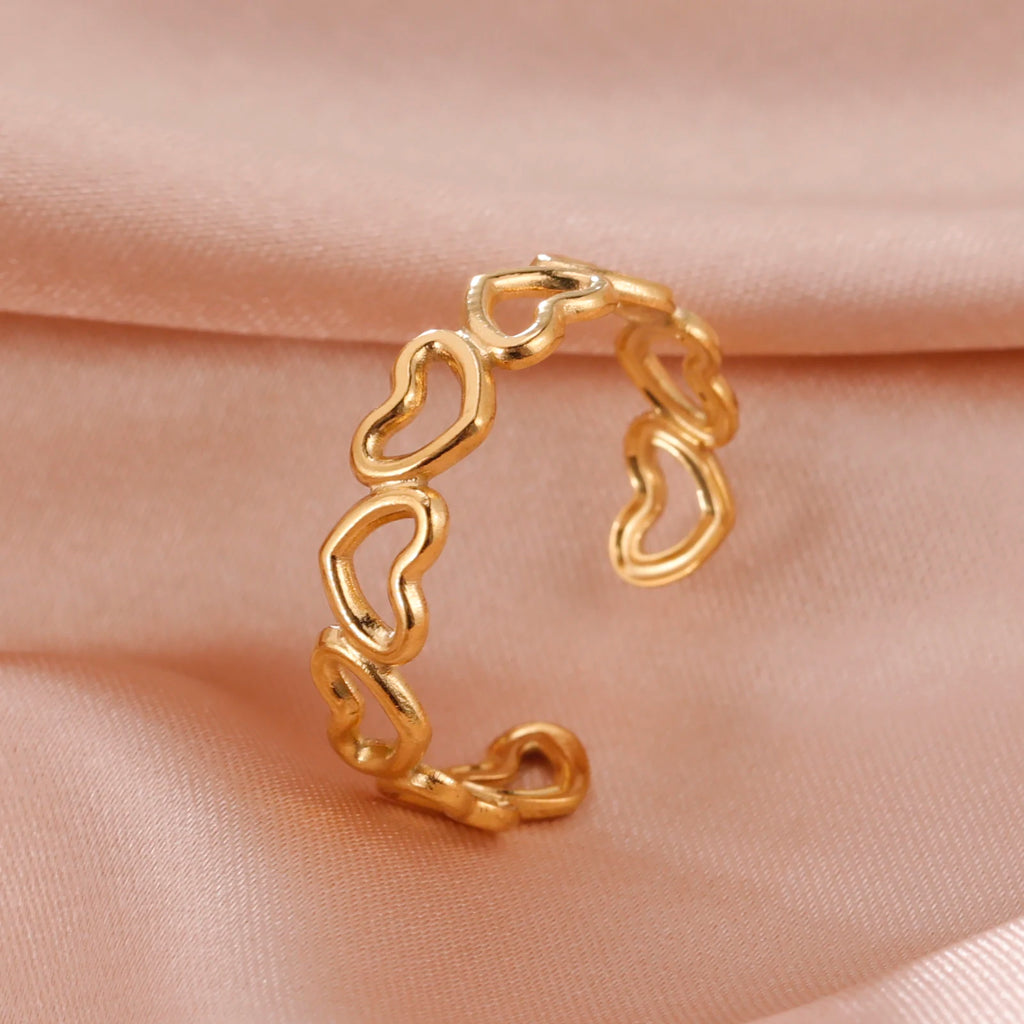 Gold hoop earring on a soft pink fabric background