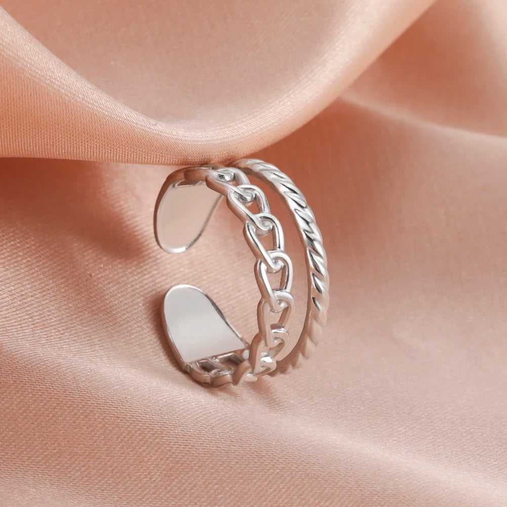 Silver chain ring on a soft pink fabric background