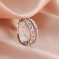 Silver chain ring on a soft pink fabric background