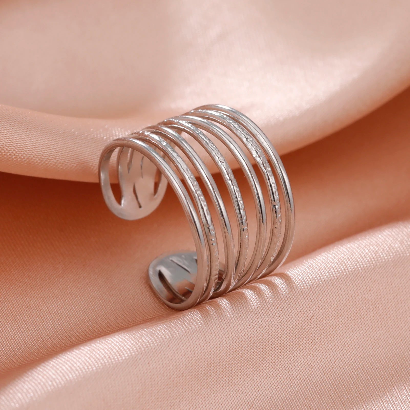 Silver coil ring on a soft pink fabric background