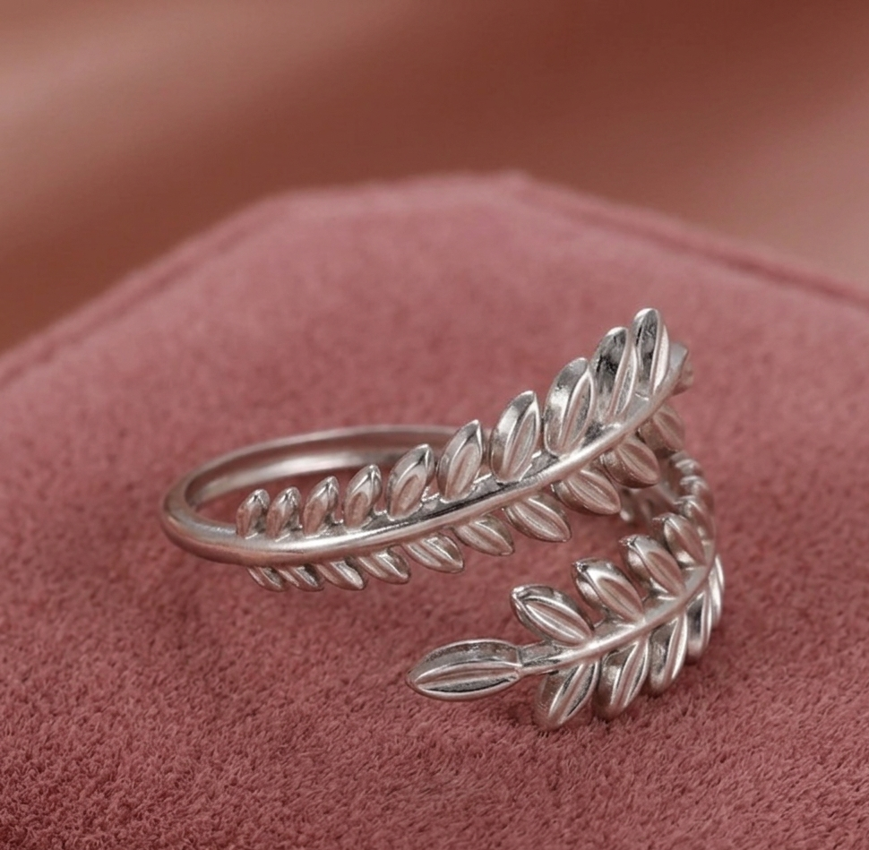 Silver leaf-shaped ring on a pink fabric background