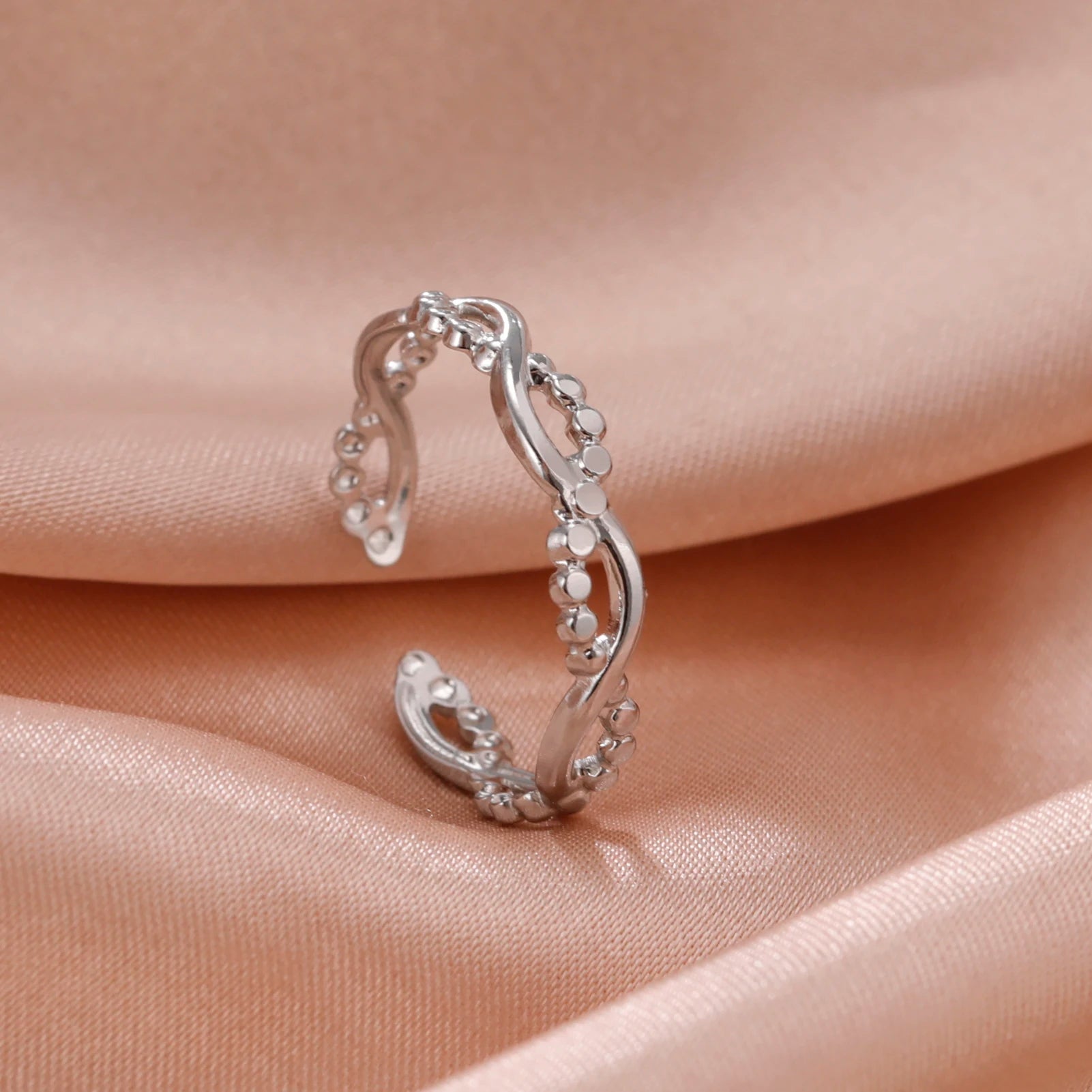 Silver open Ring cuff on a soft pink fabric background