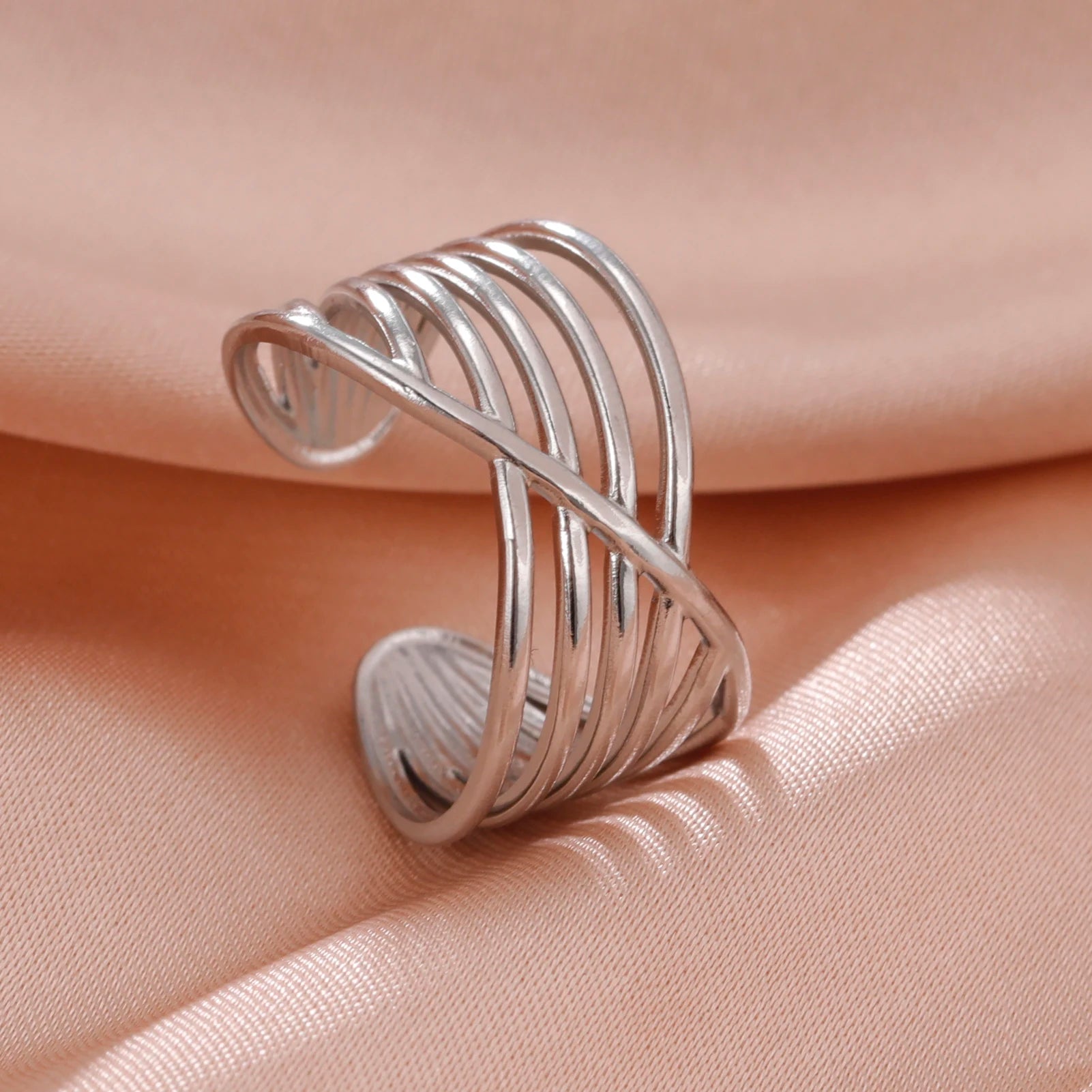 Silver wire-crafted ring on a beige fabric background